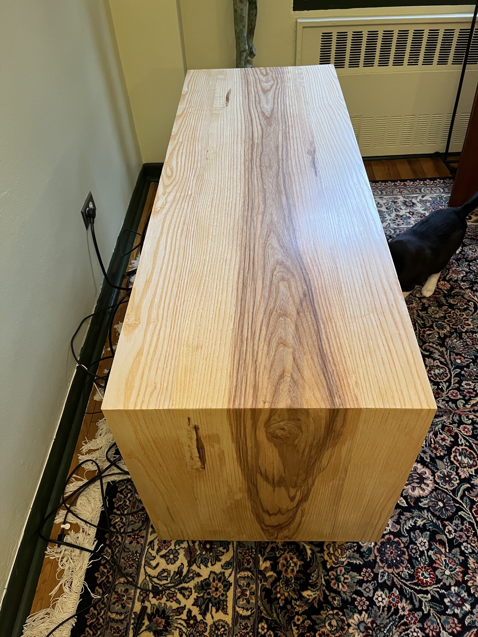 Media console made of ash, top corner continuous grain